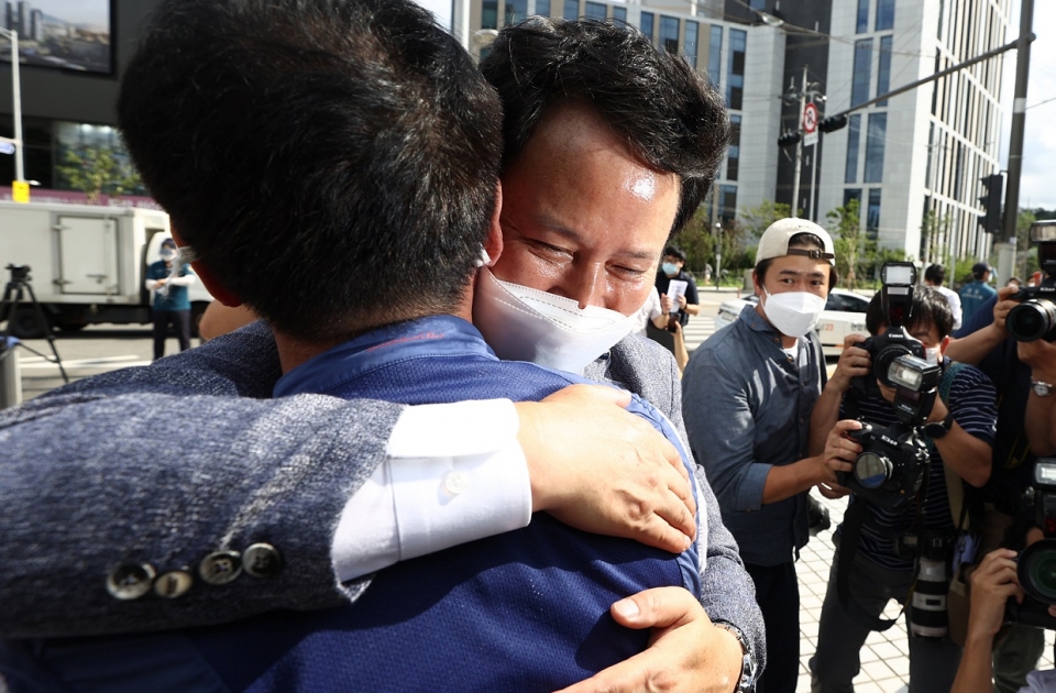 권정오 전교조 위원장이 대법원 판결 직후 감격한 표정으로 동료를 얼싸안고 있다.