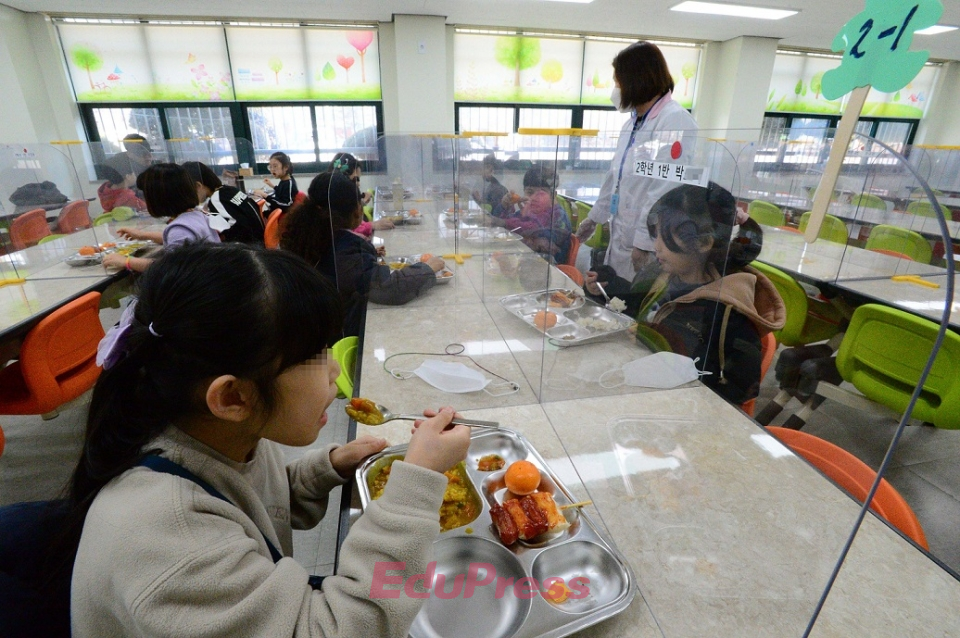 서울시내 한 초등학교 급식실. 영양교사 지도아래 학생들이 한칸 씩 띄어 앉아 식사를 하고 있다.